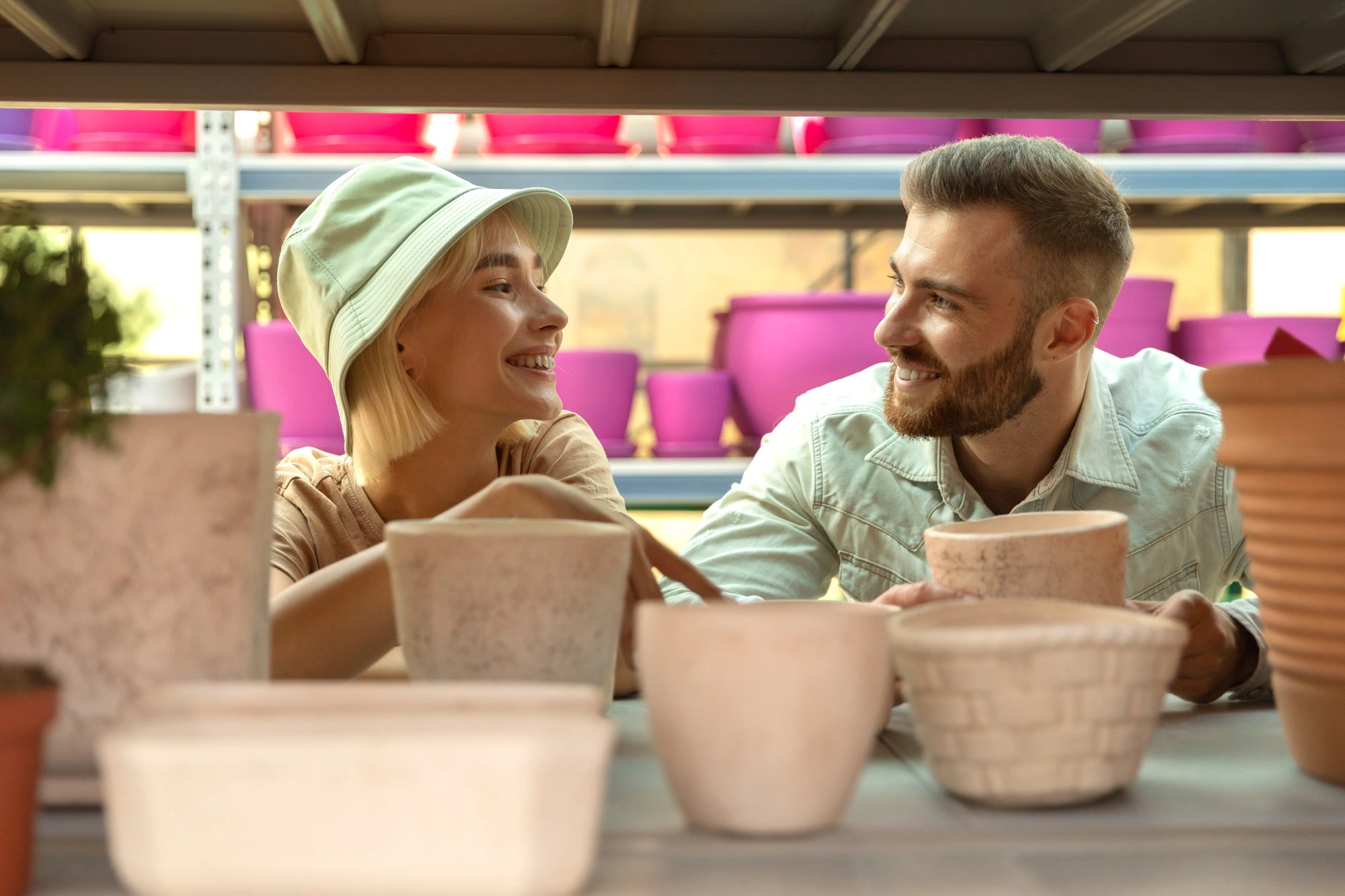 Uczestnicy oglądający własne prace na warsztatach ceramicznych