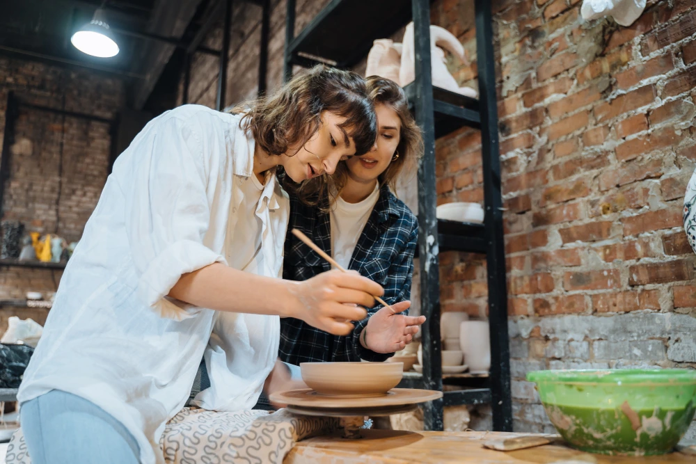 Uczestnicy warsztatów ceramicznych dla firm tworzący własne naczynia
